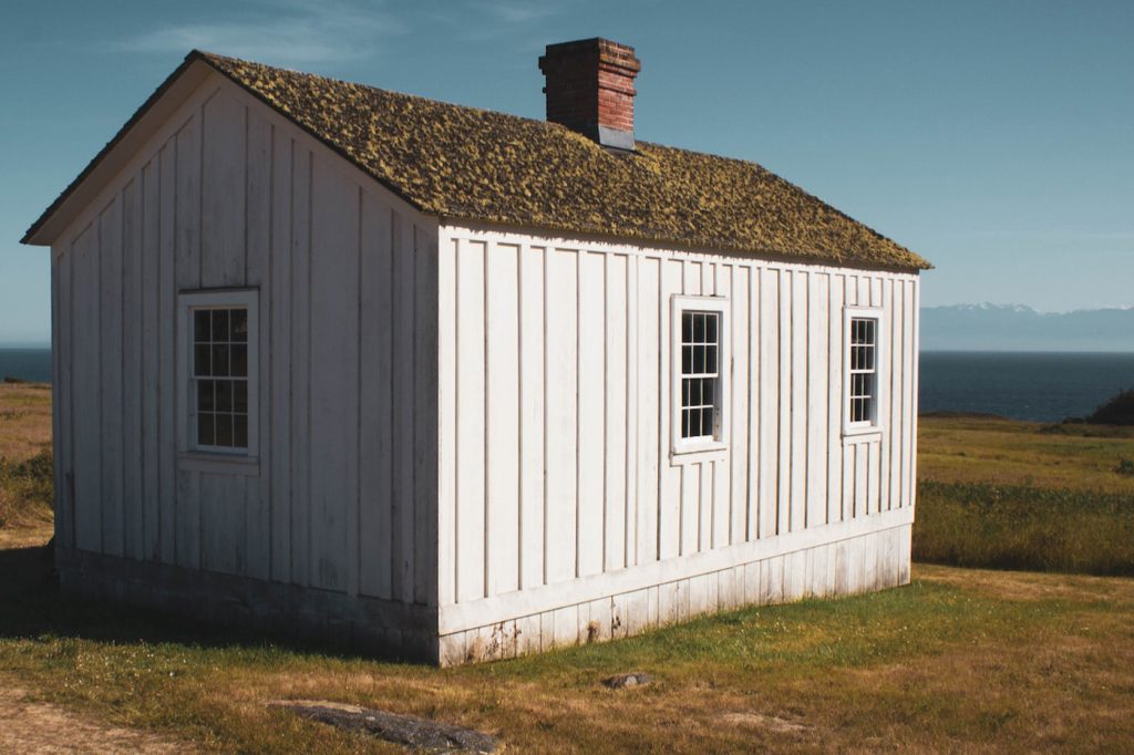 äldre hus med vit fasad i behov av renovering